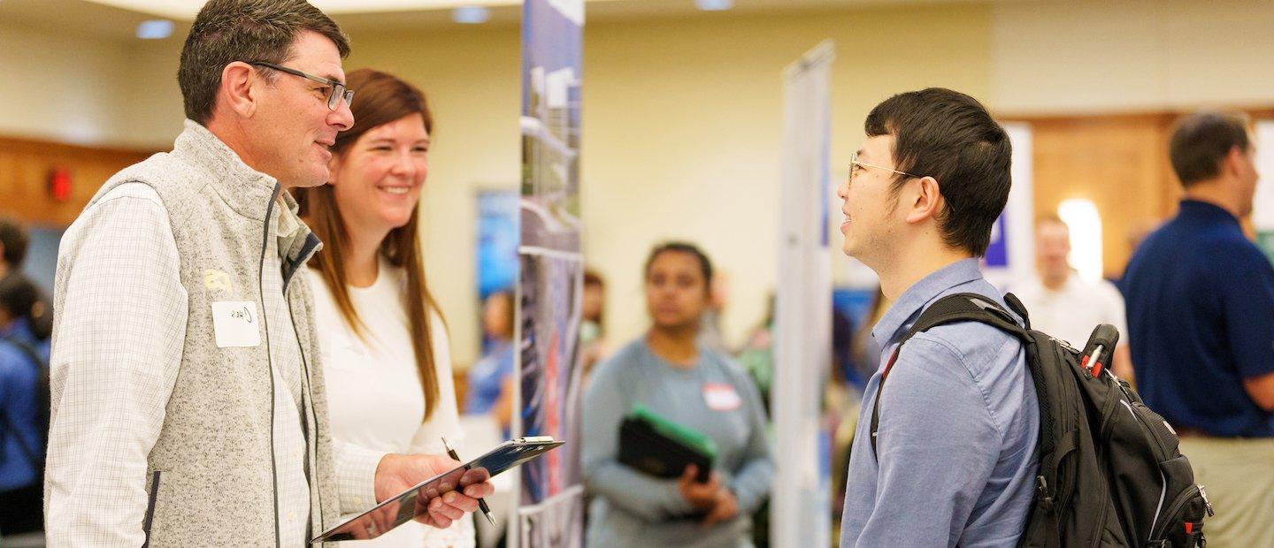 Student talking to two teachers